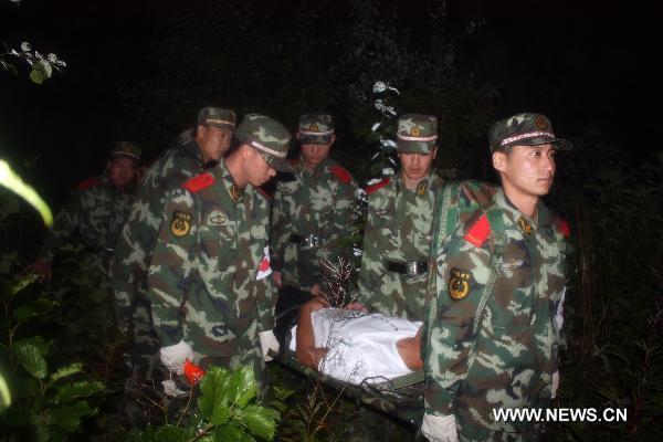 Rescuers carry an man injured in the plane crash to a hospital in Yichun City, northeast China's Heilongjiang Province, Aug. 24, 2010.