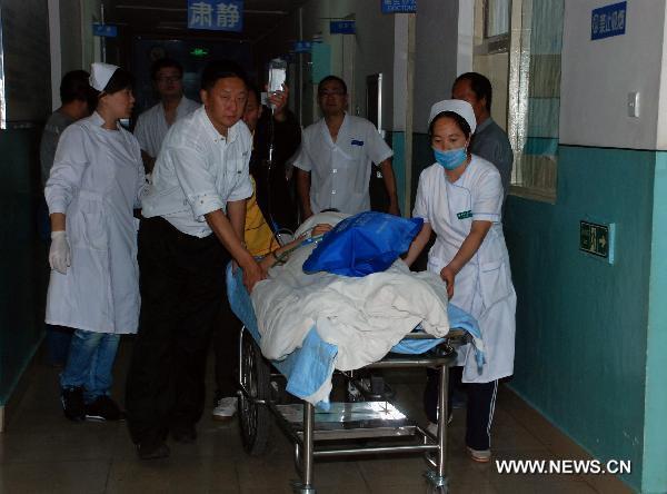 A man wounded in the air crashed is wheeled to a hospital in Yichun City, northeast China's Heilongjiang Province, Aug. 25, 2010. 