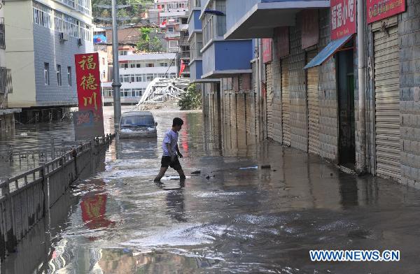 A man walks on a mud-coverd street after a significant water decline in Zhouqu County, northwest China's Gansu Province, Aug. 24, 2010.