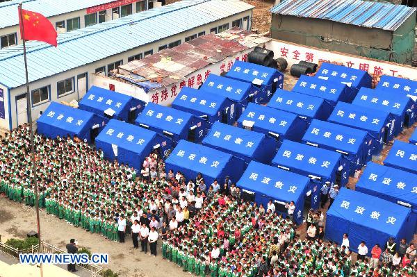 Pupils attend the flag rising ceremony at a school in mudslide-battered Zhouqu County in northwest China's Gansu Province, Aug. 25, 2010. 