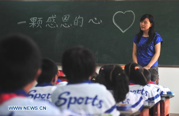 Pupils have a class at a school in mudslide-battered Zhouqu County in northwest China's Gansu Province, Aug. 25, 2010. Primary and junior middle school students in Zhouqu began their new semester Wednesday.