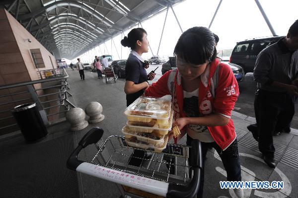 A passenger receives food for a meal at the Xinzheng International Airport in Zhengzhou, capital of central China&apos;s Henan Province, Aug. 25, 2010.
