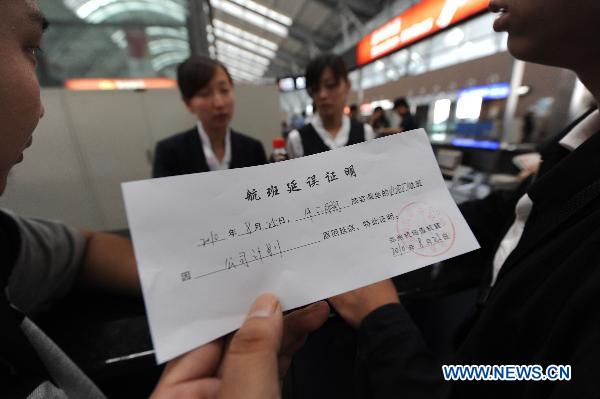 A passenger shows a certification for flight canceling at the Xinzheng International Airport in Zhengzhou, capital of central China&apos;s Henan Province, Aug. 25, 2010. 