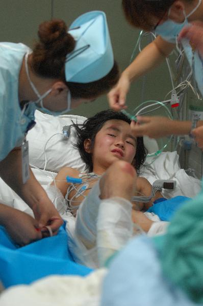 Nurses treat a injured girl at the First Affliated Hospital of Harbin Medical University in Harbin, capital of northeast China's Heilongjiang Province, Aug. 25, 2010.