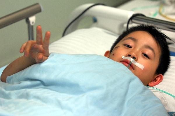 A wounded boy reacts to the reporter at the First Affliated Hospital of Harbin Medical University in Harbin, capital of northeast China's Heilongjiang Province, Aug. 25, 2010.