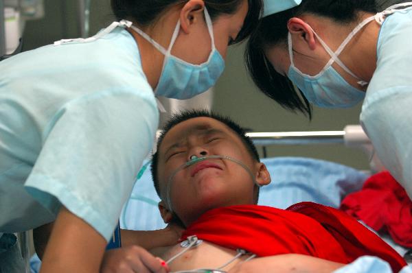 Nurses treat a injured boy at the First Affliated Hospital of Harbin Medical University in Harbin, capital of northeast China's Heilongjiang Province, Aug. 25, 2010. 