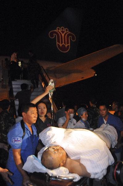 Rescuers carry a injured passerger off the plane at the Harbin Taiping International Airport in Harbin, capital of northeast China's Heilongjiang Province, Aug. 25, 2010. 