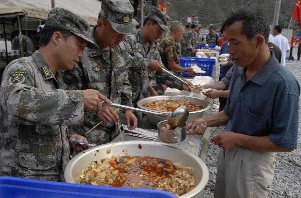  Soldiers provide food for landslide victims in a newly established shelter site in Zhouqu County, northwest China's Gansu Province, Aug. 25, 2010. 