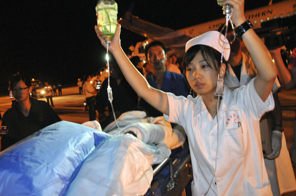 Medical workers take injured people to the plane heading for Harbin, capital city of Heilongjiang province, Aug 25, 2010. [Xinhua]