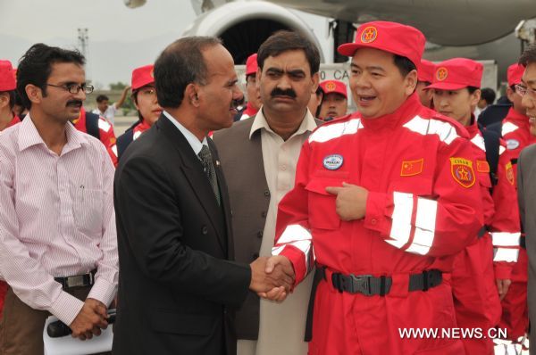 Syed Hasan Javed (2nd L, front), the additional secretary of Pakistani Foreign Ministry, shakes hands with Huang Jianfa, head of the China International Search and Rescue Team (CISAR), on their arrival at the Chaklala Airbase in Rawalpindi, Pakistan, Aug. 26, 2010. The Chinese rescue team, which is comprised of 36 medical workers and 19 rescue workers and technicians, brought 25 tones of high-tech medical equipments and medicine worth 8 million Chinese yuan. The emergency rescue team left Beijing for the flood-hit areas in Pakistan Thursday morning. (Xinhua/Ahmad Kamal) (yc) 