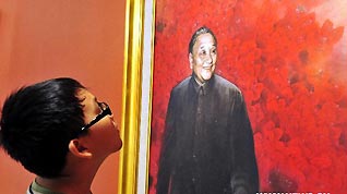 A boy looks at a painting on which Deng Xiaoping smiles in Guan Shanyue Art Museum in Shenzhen, south China's Guangdong Province, Aug. 26, 2010. The art exhibition that opened on Thusday with 90 shortlisted works aims to showcase the rapid development of Shenzhen during the past three decades since the city became a Special Economic Zone on Aug. 26, 1980.
