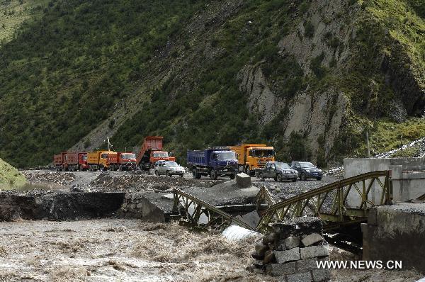Vehicles stop by a river where a bridge was detroyed by the flood in Nagqu County, southwest China's Tibet Autonomous Region, Aug. 29, 2010.