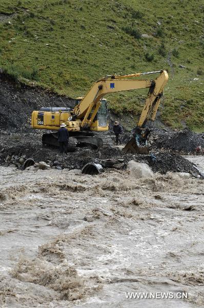 A crane works to set up an alternative path to get across a river in Nagqu County, southwest China's Tibet Autonomous Region, Aug. 29, 2010. 