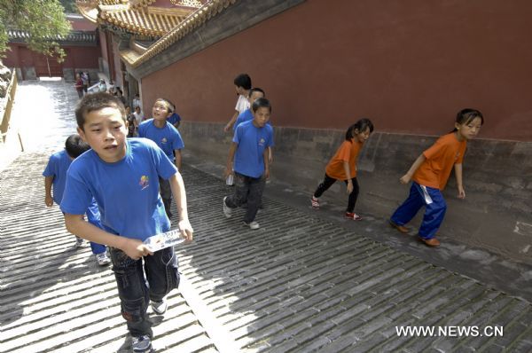 Yao Junfei(front L) walks with other children to climb Wanshou Hill in the Summer Palace in Beijing, capital of China, Aug. 30, 2010.