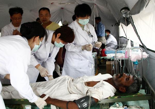 Chinese medical workers check the condition of a Pakistani flood victim at a mobile hospital set up by a Chinese rescue and relief team in Thatta, one of the worst-hit regions in Pakistan, on Aug. 31, 2010. 