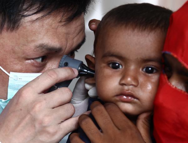 A Chinese doctor checks the ear of a Pakistani child at a mobile hospital set up by a Chinese rescue and relief team in Thatta, one of the worst-hit regions in Pakistan, on Aug. 31, 2010. 