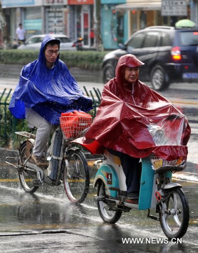 Two motorists are seen in rain in Hangzhou City, capital of east China's Zhejiang Province, Aug. 31, 2010. The tropical storm Lionrock, the sixth of this season, was moving northeastward slowly. It will probably land on south China's Guangdong Province or Fujian Province on Wednesday evening or Thursday morning, bringing gusty winds and heavy rainfall to the regions, according to local meteorological stations. The seventh tropical storm Kompasu and the eighth tropical storm Namtheun were also moving near the southeast coastline of China. The three tropical storms might interact with one another and cause unpredictable outcome. (Xinhua/Wang Dingchang) (lb) 