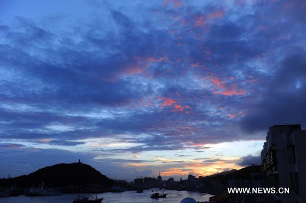 Crimson clouds at sunset are seen in a harbour of Zhoushan City, east China&apos;s Zhejiang Province, Aug. 31, 2010. 