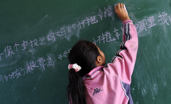 An orphan writes on the blackboard during class at a charity school in Liangshan Yi Autonomous Prefecture, southwest China&apos;s Sichuan Province August 27, 2010.