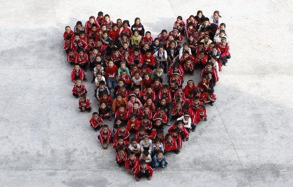 Orphaned students sit as the shape of a heart for photos at a charity school in Liangshan Yi Autonomous Prefecture, southwest China&apos;s Sichuan Province August 27, 2010.