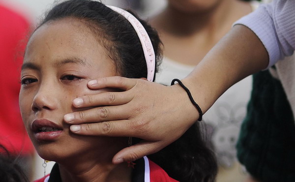 A teacher wipes away tears of an orphaned student who is missing her family during class at a charity school in Liangshan Yi Autonomous Prefecture, southwest China&apos;s Sichuan Province August 27, 2010. August 27, 2010. 