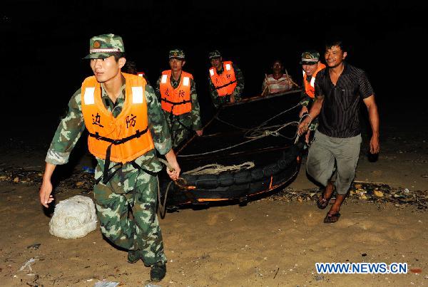 Soldiers help the local fishermen coming ashore in Shishi, southeast China's Fujian Province, on Sept. 1, 2010.