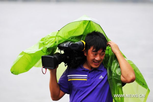 A cameraman is seen in the wind by sea in southeast China&apos;s Fujian Province, Aug. 31, 2010. 