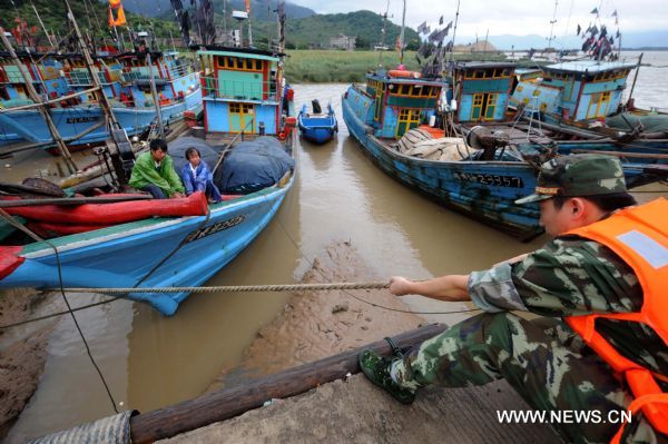 Soldiers help fisherfolks to stabilize fishing boats in a harbour of Changle City, southeast China&apos;s Fujian Province, Aug. 31, 2010.