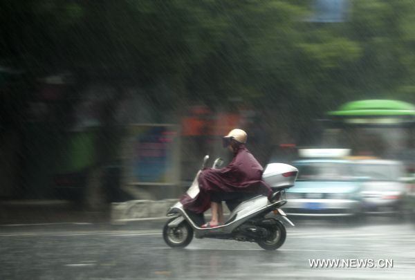 A resident rides motorcycle in rain in Zhangzhou City, southeast China's Fujian Province, Sept. 2, 2010. 