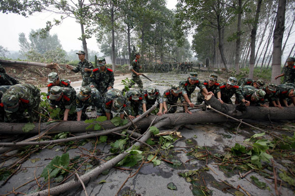 Soldiers clear fallen trees blocking a road in Luoyang on Sept 4.