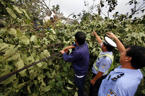 Traffic policemen guide a truck trapped by fallen branches in Luoyang on Sept 4.