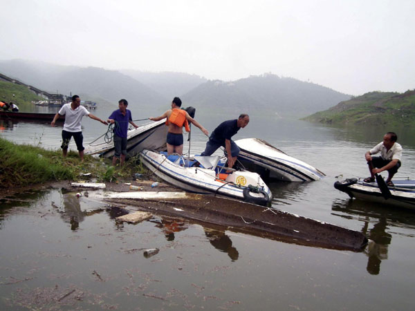 Villagers in a scenic spot in Luoyang try to retrieve boats sunk due to the storm on Sept 4.