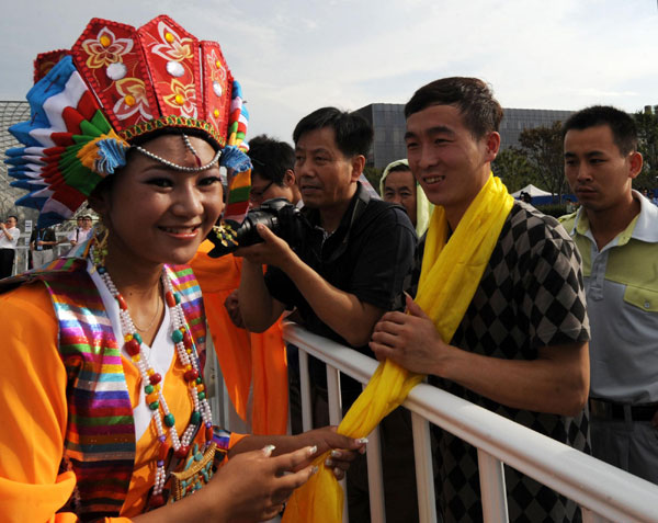 A performer from Tibet presents a hada to a visitor during the opening ceremony of Tibet Culture Week on Sept 1.