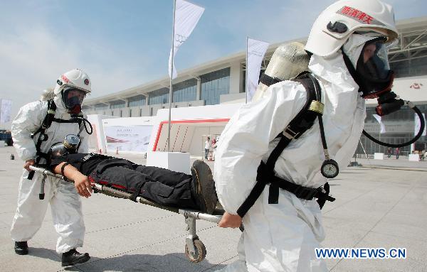 Two rescuers carry a simulated victim poisoned by gas in an anti-terror drill at Tianjin Meijiang Convention and Exhibition Center in Tianjin, east China, Sept. 8, 2010, as a part of preparation for the 2010 Summer Davos Forum which will kick off Sept. 13. 