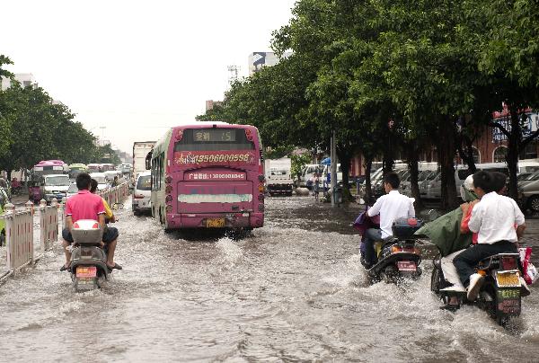 Vehicles pass by a ponding in downtown Jinjiang, southeast China's Fujian Province, Sept. 10, 2010. Meranti, the 10th typhoon that hit China this year, made landfall at Fujian on Friday, according to provincial flood control authorities.