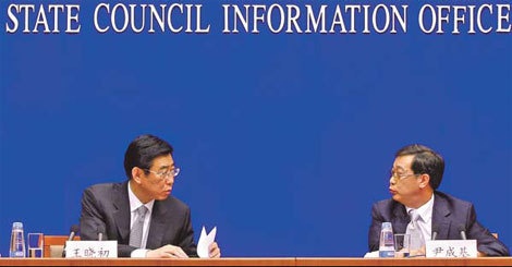 Vice-Minister of Human Resources and Social Security Wang Xiaochu (left) exchanges views with Yin Chengji, the ministry's spokesman, at a news briefing in Beijing on Friday. 