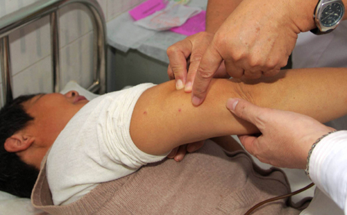 Medical experts from the Ministry of Health and the Chinese Center for Disease Control and Prevention diagnose a patient who is suspected of suffering human granulocytic anaplasmosis contracted by a tick bite, in a hospital in Shangcheng County of Henan Province, on Friday.