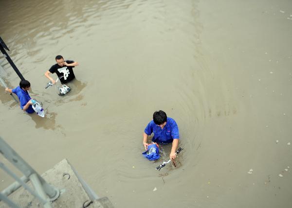 People wade through the waterlogged Jiangnan Street in Hangzhou, capital of east China's Zhejiang Province, Sept. 11, 2010.