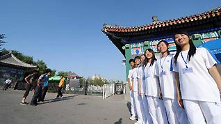 Volunteers offer services outside the Memorial Hall of Zhou Enlai and Deng Yingchao in Tianjin, north China, Sept. 11, 2010.
