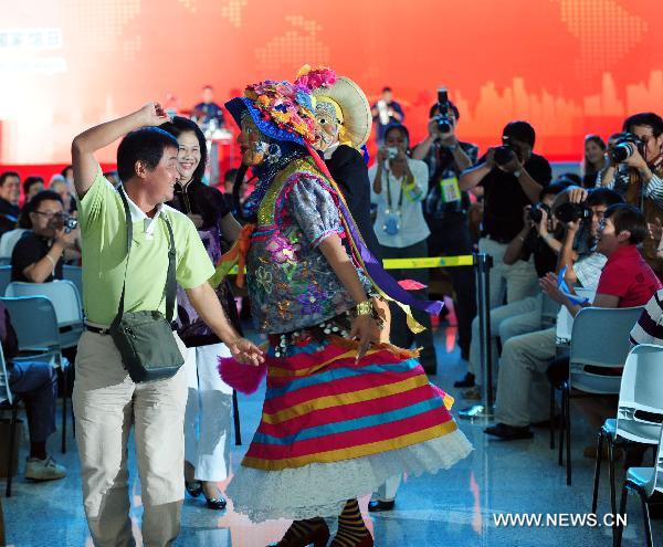 An artist from Nicaragua dances with a spectator during a ceremony marking the National Pavilion Day of the Republic of Nicaragua in the Shanghai World Expo Park in Shanghai, east China, Sept. 14, 2010. 