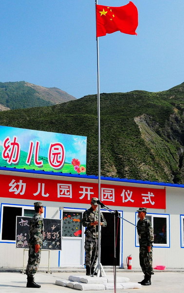 A flag raising ceremony is held during the opening of a newly-built kindergarten for victims of mudslide-hit Zhouqu in Gansu Province on September 14, 2010.