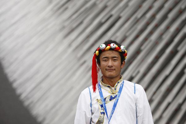 A student from quake-hit Yushu County of northwest China's Qinghai Province poses for a photo in front of the Britain Pavilion at the World Expo Park in Shanghai, east China, Sept. 15, 2010. 