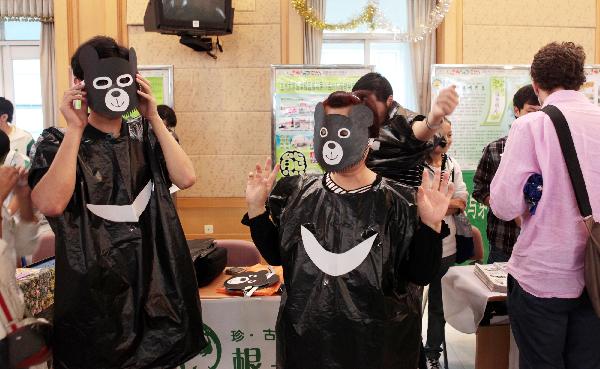 Students get dressed like black bears to call for animal protection during a summit at Beijing 101 Middle School in Beijing, capital of China, on Sept. 18, 2010. 