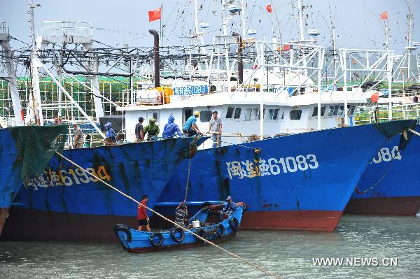 Fishermen fasten their fishing boats at the Huangqi port in Lianjiang County, southeast China's Fujian Province, Sept. 19, 2010. 