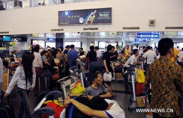 Tourists wait at Xiamen Airport in Xiamen, southeast China's Fujian Province, Sept. 20, 2010. 