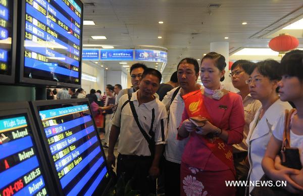 People check flight information at Xiamen Airport in Xiamen, southeast China's Fujian Province, Sept. 20, 2010. 