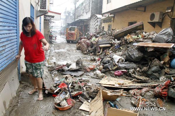 A woman walks on a flooded street in Kaohsiung County, southeast China's Taiwan, Sept. 20, 2010. 