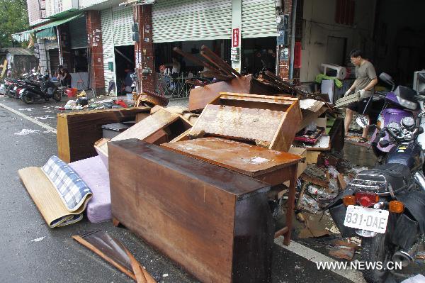 Local residents clean furnitures and articles marinated in floods in Kaohsiung County, southeast China's Taiwan, Sept. 20, 2010.