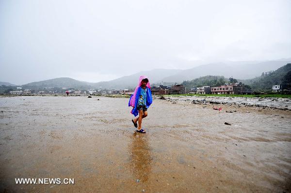 A boy walks on a mud-covered farmland in Qianpai Town in Xinyi, south China&apos;s Guangdong Province, Sept. 22, 2010. Flooding and landslides caused by Typhoon Fanabi have left 18 people dead and at least 44 still missing, according to the Ministry of Civil Affairs on Wednesday.