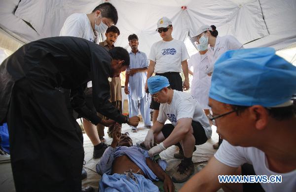 Doctors of China International Search and Rescue Team treat a patient at a tent hospital in Makly town of flood-hit Thatta in southern Pakistan, Sept. 21, 2010. 
